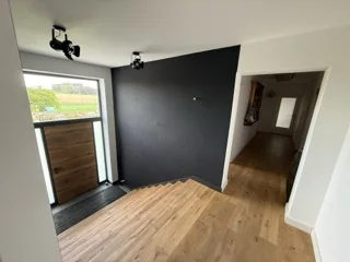 Zweite Ansicht eines Innenraums mit dunklen Akzentwänden und weißen Wandflächen