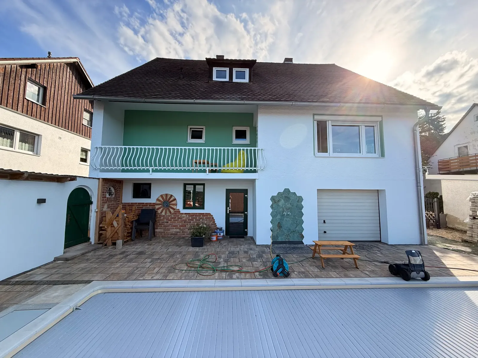 Wohnhaus mit grün-weißer Fassadengestaltung und klar abgesetzten Flächen