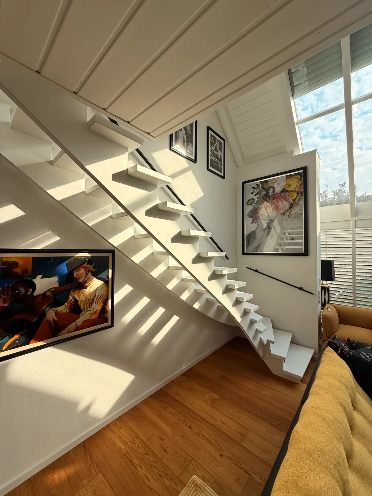 Heller Wohnbereich mit weiß gestalteter Treppe und sauber ausgeführten Wandflächen